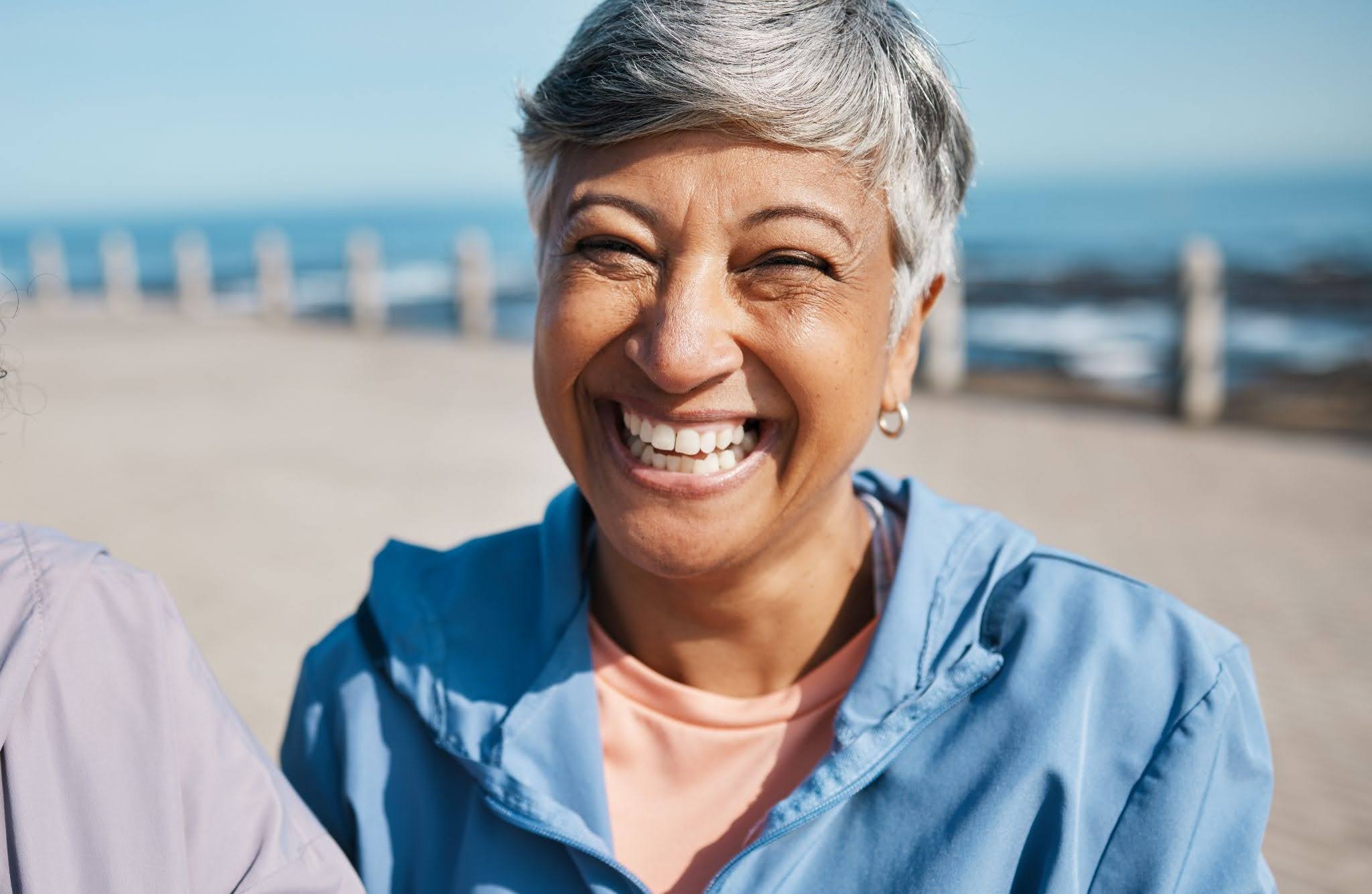 woman smiling on beach after seeing specialized bridge dentist in austin tx